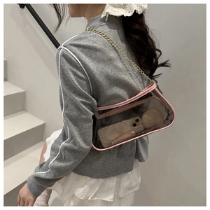 Detailed side view of a clear PVC baguette bag with pink leather trim and gold chain strap