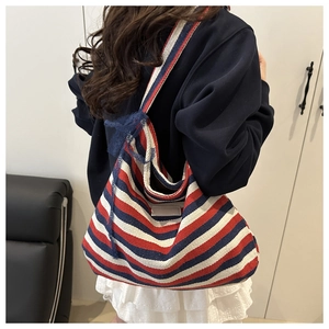 Detail view of large canvas tote bag with red, white, blue stripes and a lace bow
