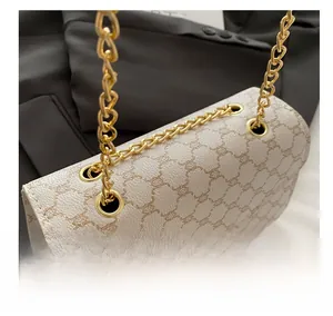 Détail du sac à bandoulière en cuir blanc avec chaîne dorée et motifs élégants