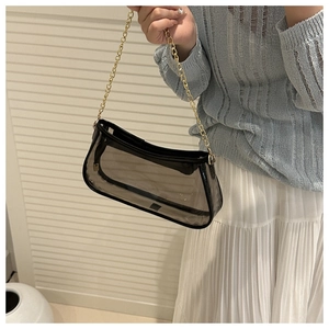 Detail view of transparent black PVC shoulder bag with sleek golden chain strap