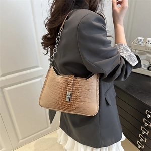 Brown crocodile pattern shoulder bag with silver chain strap worn with gray blazer