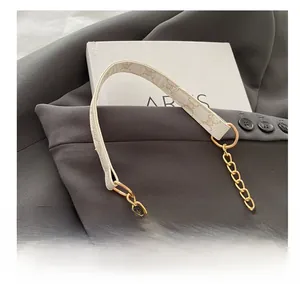 Détail de la bandoulière en cuir blanc avec chaîne dorée et motif monogramme vintage