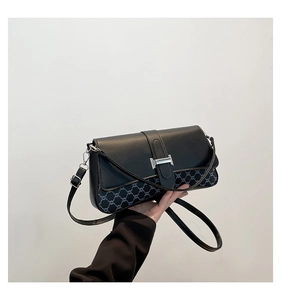 Detail of vintage crossbody bag showing black leather trim and monogram canvas texture