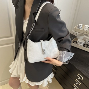White crocodile pattern shoulder bag with silver chain strap shown on a female model