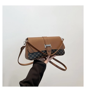 Detail view of vintage brown patchwork crossbody bag with silver buckle and monogram pattern
