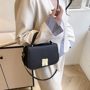 Sac bandoulière minimaliste en cuir noir avec boucle dorée et bandoulière chaîne