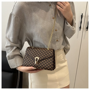 Détail du sac marron vintage à monogramme avec chaîne dorée et boucle fer à cheval