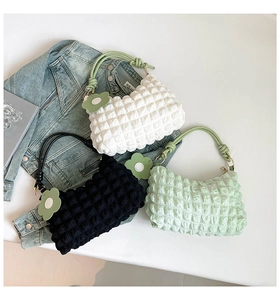 Detail of bubble texture handbags in white, black and green with floral charms