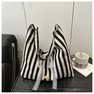 Detail of canvas tote bag with black and white stripes and handmade lace bow ornament