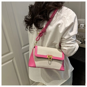 Detail of canvas shoulder bag with pink faux leather trim and gold square swivel lock