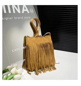 Détail du sac cabas en daim camel avec franges et doubles poignées dans un décor moderne