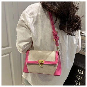 Detail of a chic patchwork shoulder bag with pink leather trim and golden metal clasp