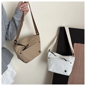 Detail of minimalist nylon crossbody bags showing adjustable straps and zipper pockets