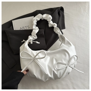 Detail of white PU leather cloud bag with pleated texture and bow knots decoration