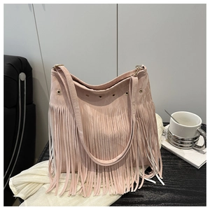 Détail du sac à bandoulière en daim rose avec de longues franges et des œillets en métal