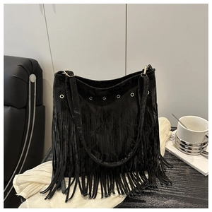 Détail d'un sac cabas en velours noir avec œillets dorés et longues franges