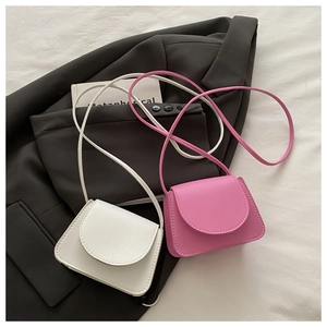 Detailed view of mini white and pink crossbody bags with pebbled leather and curved flaps