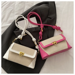 Detail of color-block canvas and leather flap bags with gold U-shaped buckles