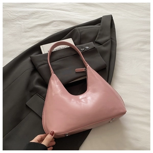 Detail of pink faux leather hobo bag with silver bottom studs and FASHION logo