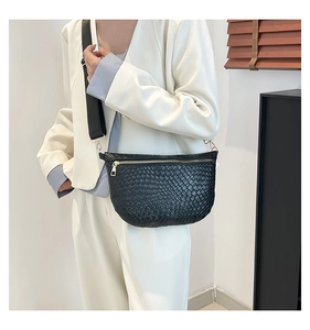 Detail of black woven crescent bag with gold hardware and wide adjustable shoulder strap