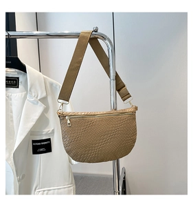Détail de la texture tressée sur le sac demi-lune kaki avec ferrures dorées chic
