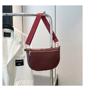 Détail du sac bandoulière bordeaux tissé avec fermeture éclair dorée et sangle large