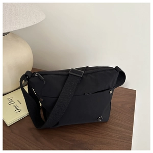Detail of adjustable wide fabric strap and nylon texture on minimalist crossbody bag
