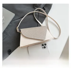 Top view of a modern cream triangular handbag with a shimmering silver glitter flap