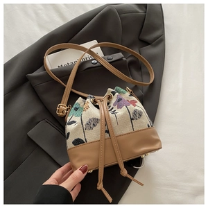 Detail der Kordelzug-Beuteltasche mit Blumenstickerei und braunem Lederbesatz