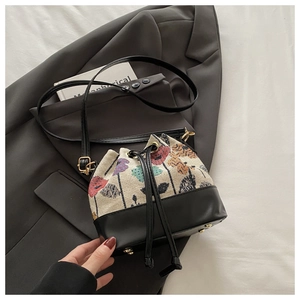 Detail der Vintage-Beuteltasche mit floralem Jacquard-Stoff und schwarzem Leder