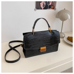 Close-up of black crocodile pattern leather texture with golden metal buckle hardware