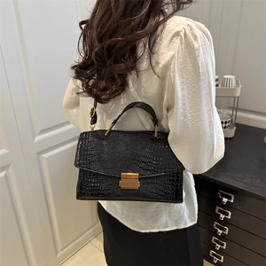 Large black crocodile pattern tote bag with gold buckle and long shoulder strap