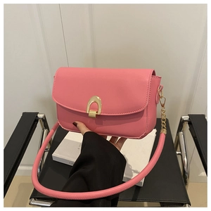 Détail du sac bandoulière rose avec boucle fer à cheval dorée et accent de chaîne