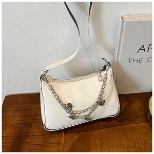Detail view of white quilted PU leather handbag with butterfly chain and silver hardware