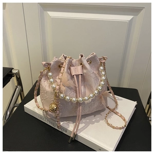 Vue détaillée du sac seau en dentelle rose avec papillon 3D et poignée en perles