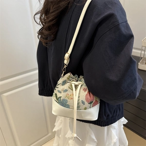 Vintage floral embroidery drawstring bucket bag with white leather straps and gold hardware