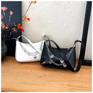 Detail of white quilted and black patent leather baguette bags with butterfly chains