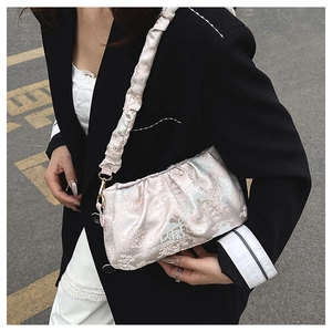 Sac à bandoulière rose à paillettes avec motif floral jacquard sur un mannequin