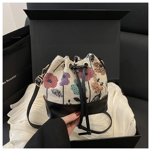 Detail of floral bucket bag in a black gift box with white satin lining