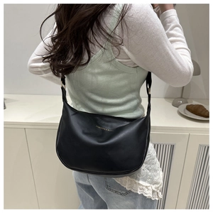 Close-up of black PU leather crescent bag featuring gold Fashion & Bags logo print