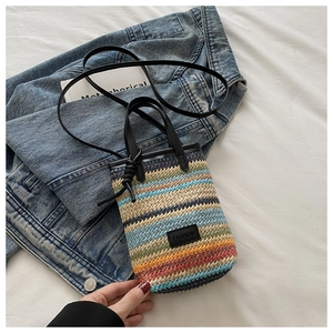 Detail of colorful striped straw handbag with FASHION label on blue denim background