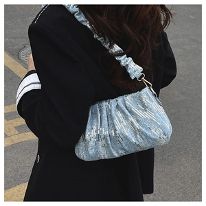 Detail of light blue sequined cloud bag featuring pleated straps and gold hardware