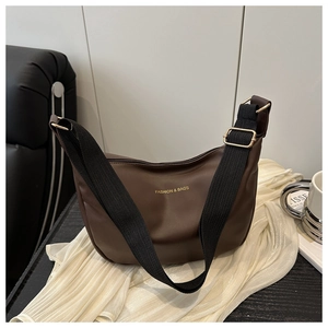 Detail of the brown PU leather crescent bag with adjustable wide strap and golden hardware