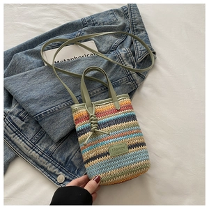 Detail of colorful striped woven mini bag with green leather trim and Fashion tag
