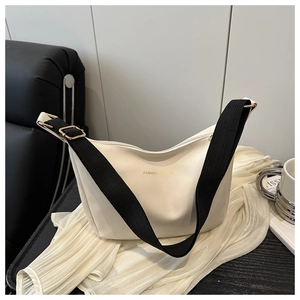 Detail of adjustable wide fabric strap and golden buckle on cream white PU leather tote