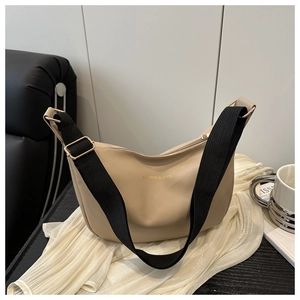 Detail of minimalist beige PU tote with golden lettering and wide black strap