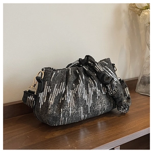 Macro detail of dark grey sequin cloud bag with soft pleats and golden metal buckles