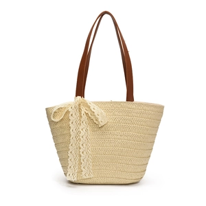 Handwoven straw shoulder bag in cream with brown handles and a lace bow detail