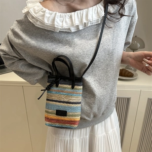 Mini colorful striped straw woven tote bag with crossbody strap shown on a model