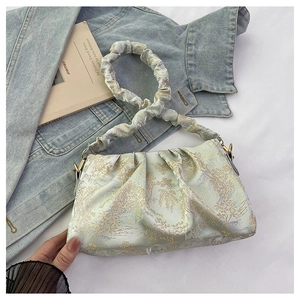 Detail of light green jacquard handbag featuring vintage floral texture and pleated handle